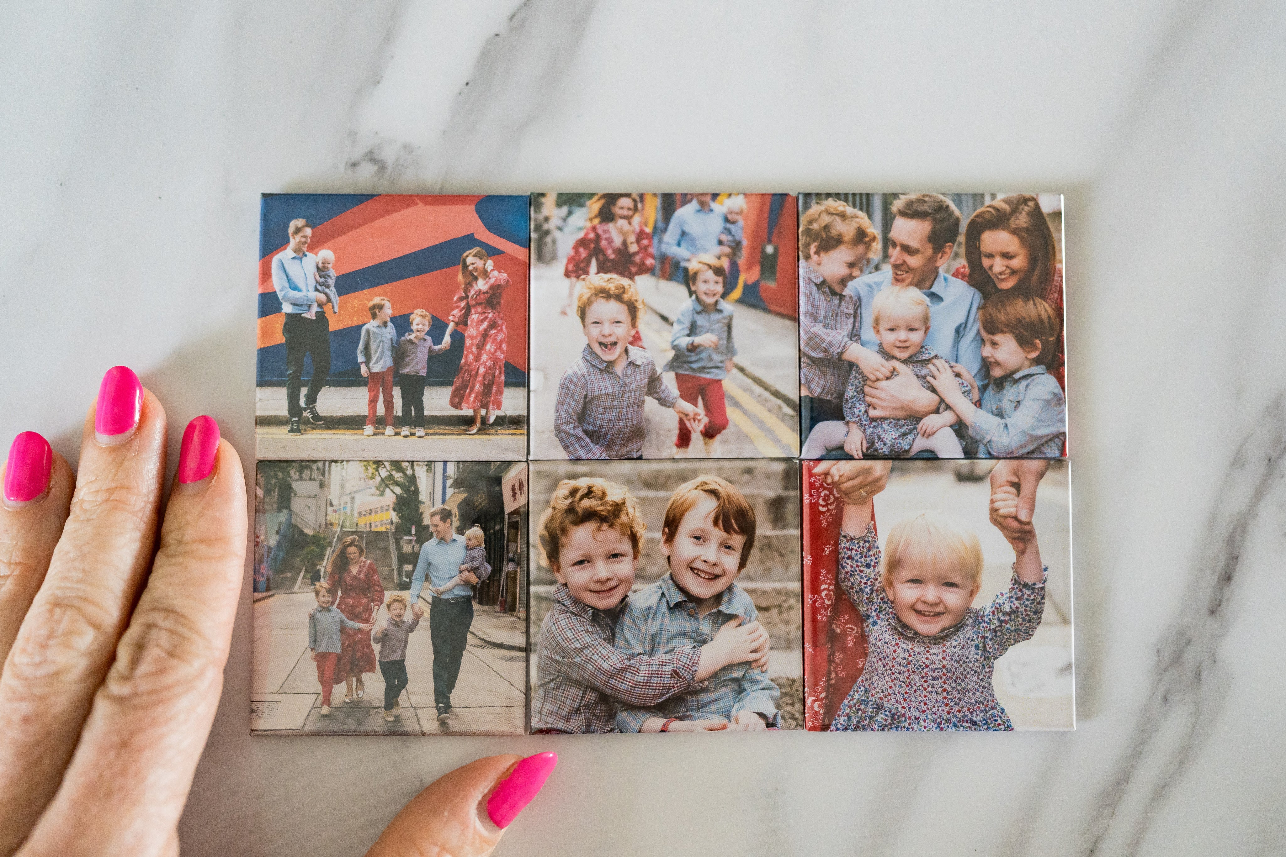 Collage of family photos on a marble surface with a hand holding it.